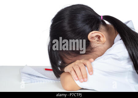 Cinese asiatici bambina in uniforme scolastica che dorme sul tavolo in isolati di sfondo bianco Foto Stock