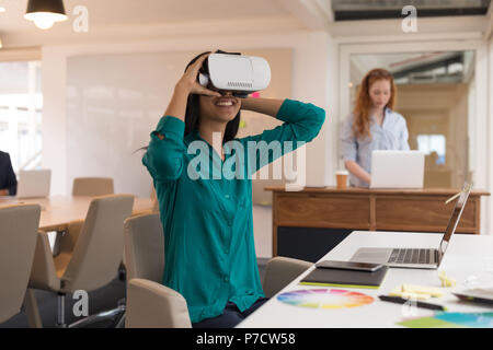 Femmina designer grafico utilizzando la realtà virtuale auricolare Foto Stock