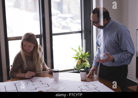 Colleghi di lavoro discutendo su cianografia Foto Stock