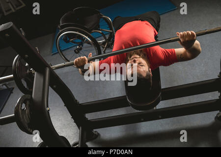 Uomo disabile facendo petto allenamento sulla pressa da banco con barbell Foto Stock