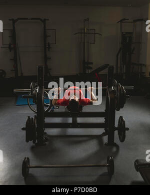 Uomo disabile facendo barbell bench premendo durante l'esercizio Foto Stock