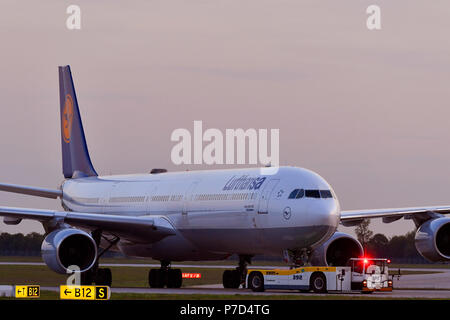 Lufthansa, Airbus A340-600, a spingere indietro il carrello, crepuscolo, Aeroporto di Monaco di Baviera, Baviera, Baviera, Germania Foto Stock