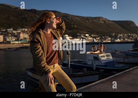 Donna schermare gli occhi vicino al dock Foto Stock