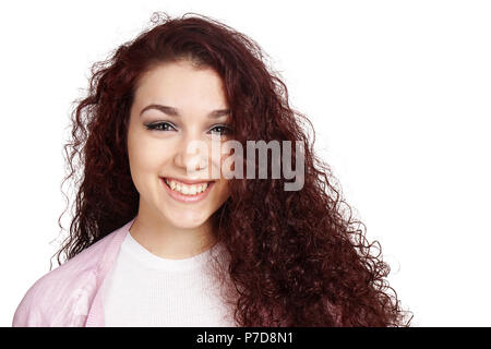 Felice ragazza adolescente con lunghi capelli ricci e sorriso toothy isolato su bianco Foto Stock