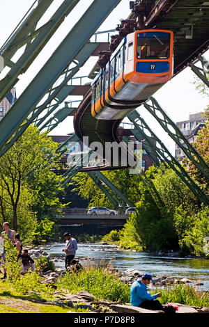 La gente sul fiume Wupper con movimentazione ferroviaria di sospensione sopra di esso, Wuppertal, Bergisches Land, Nord Reno-Westfalia, Germania Foto Stock