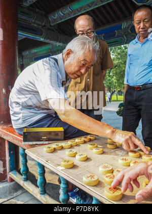 Uomo anziano giocando Cinese tradizionale a scacchi nel lungo corridoio del Tempio del Cielo a Pechino, Cina Foto Stock