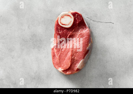 Materie di carni bovine sul tessuto osseo su cemento bianco sfondo, vista dall'alto Foto Stock