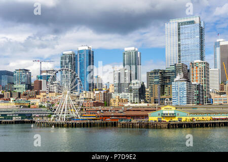 Seattle Waterfront, piloni 56 e 57, e lo skyline su un luminoso e giorno nuvoloso, vista dal Puget Sound, nello Stato di Washington, USA. Foto Stock