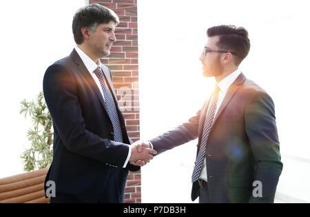 Uomini d'affari si stringono la mano mentre in piedi nel corridoio di office Foto Stock