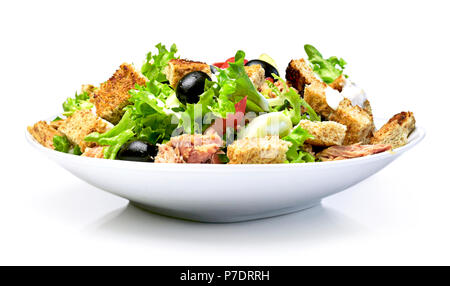 Deliziosa insalata fresca piatto su una piastra bianca, isolato su sfondo bianco. Mangiare sano scena, freschi lattuga, pomodori, tonno, cetriolo, arrosto di brea Foto Stock
