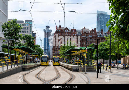 Due moderni giallo Metrolink tram fermano a St Peters Square Station nel centro di Manchester Foto Stock