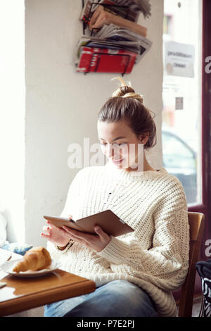 Donna che utilizza digitale compressa in cafe Foto Stock