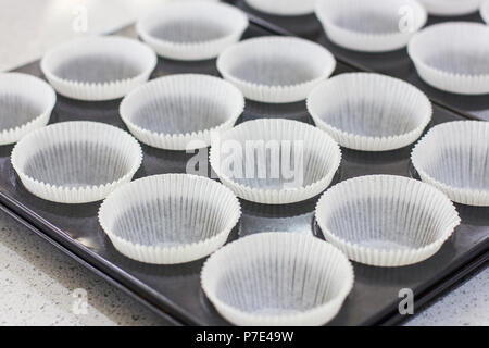 Svuotare i moduli cartacei per muffin e tortine in un vassoio di metallo Foto Stock