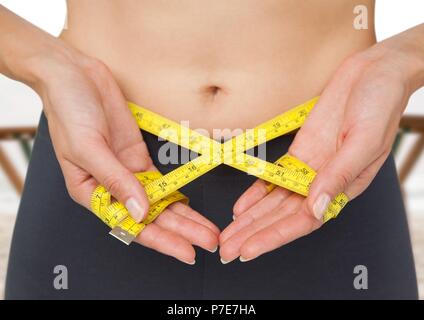 Donna di peso misurazione con nastro di misurazione sulla vita Foto Stock