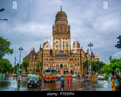 MUMBAI, India - 24 Giugno 2018 : Best autobus che corre lungo la strada di BMC edificio comunale nella città di Mumbai, India. Architettura britannica e historica Foto Stock