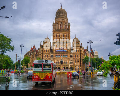 MUMBAI, India - 24 Giugno 2018 : Best autobus che corre lungo la strada di BMC edificio comunale nella città di Mumbai, India. Architettura britannica e historica Foto Stock