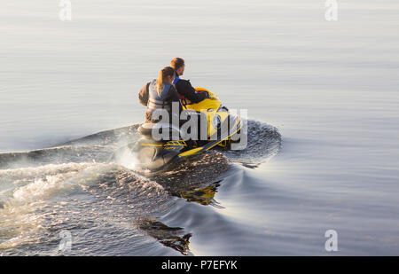 29 Giugno 2018 Una giovane coppia a bordo di una potente Yamaha Jet-Ski come loro capo a mare da Groomsport Harbour Irlanda del Nord su una calma piatta sera Foto Stock