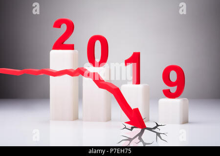 Freccia rossa di cracking superficie bianca di fronte decrescente di anno 2019 grafico Foto Stock