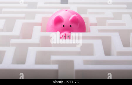 Close-up di Rosa Piggybank nel centro di bianco labirinto Foto Stock