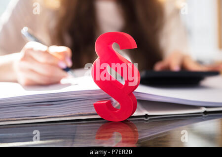 Close-up di un punto rosso simbolo nella parte anteriore della persona che lavora al lavoro Foto Stock