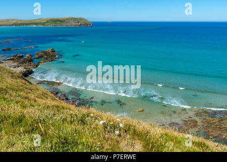 Una bella scena con onde a terra di lavaggio come visto dal sentiero costiero da Polzeath a Daymer Bay in North Cornwall, Regno Unito. Foto Stock