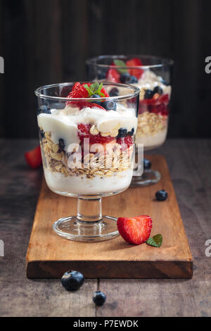 Parfait di yogurt fatto con lo yogurt greco, frutti di bosco freschi e avena. Foto Stock