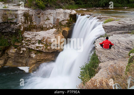 Metà maschio età meditando accanto alla cascata, Lundbreck cade, Alberta, Canada. Foto Stock