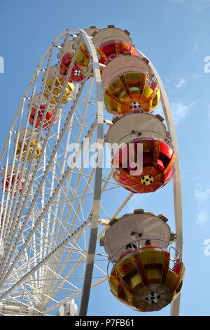 Ruota Gigante in aria, cielo blu, persone all'interno dei carri Foto Stock