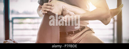 Fisioterapista dando la terapia al ginocchio di una donna Foto Stock