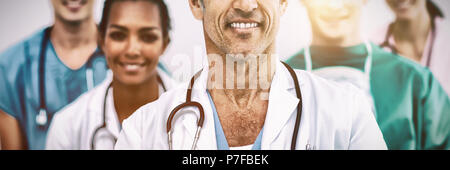 Ritratto di medico senior in piedi davanti al suo compagno di squadra Foto Stock