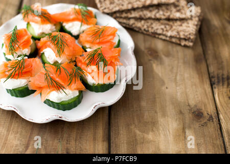 Il cetriolo e salmone, piccoli spuntini su una piastra. Spazio di copia Foto Stock