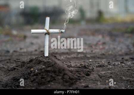 Un tabacchi tomba in un cimitero. Una tomba di tabacco in un cimitero. La morte per cancro ai polmoni. I pericoli del fumo. Anti tabacco una foto concettuale. Foto Stock