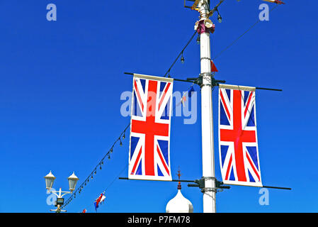 Due Union Jack Flag attaccata alla lampada posta contro il cielo blu in estate Foto Stock