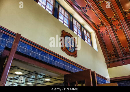 Berlin Dahlem-Dorf U-Bahn metropolitana stazione ferroviaria sulla U 3 linea. Edificio storico interno con piastrelle blu, il pannello in legno e il soffitto antico orologio. Foto Stock