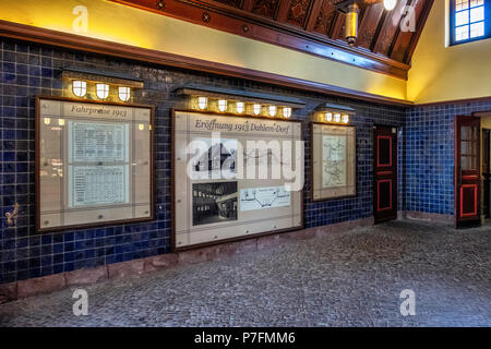 Berlin Dahlem-Dorf U-Bahn metropolitana stazione ferroviaria su U 3 linea. Edificio storico interno con piastrelle blu, pannello di legno sul soffitto, pannelli informativi Foto Stock