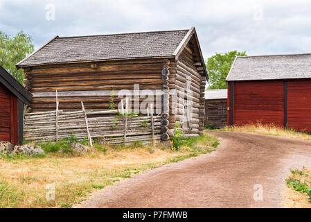 Villaggio Tradizionale edificio di stoccaggio accanto a una strada di campagna passando alcuni granai in background. Ubicazione Stensjo in Smaland, Svezia. Foto Stock