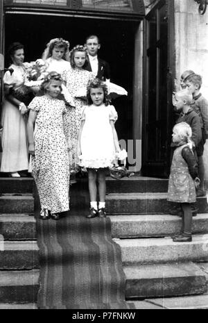 Coppia di sposi e i bambini sono in piedi sulle scale dopo la cerimonia, ca. 1955, Lipsia, Germania Foto Stock