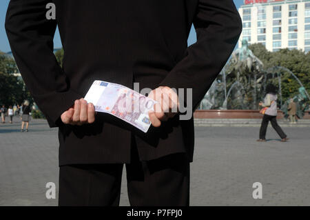L uomo si nasconde una banconota da 500 euro dietro la schiena, Berlino, Germania Foto Stock