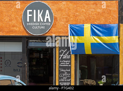 Liverpool, Regno Unito. 6 luglio 2018. "Fika' svedese di caffé cafe su Woolton Rd, Liverpoo,l pende una bandiera fuori per mostrare che si tratta di supporto per il calcio svedese team in vista della Coppa del Mondo Quarti di Finale partita contro l'Inghilterra. Credito: Ken Biggs/Alamy Live News. Foto Stock