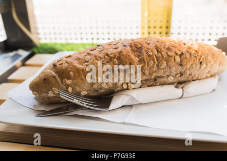 Fresh grano intero sandwich con prosciutto e formaggio luce sul tavolo di legno in corrispondenza della finestra negozi Foto Stock