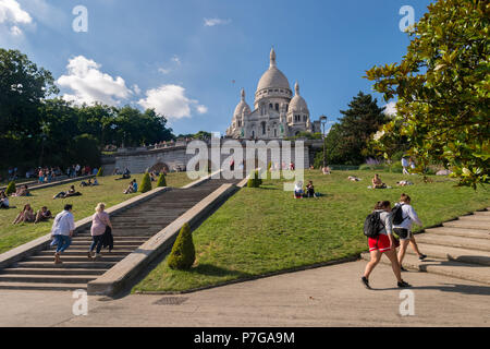 Parigi, Francia - 25 Giugno 2018: persone rilassarsi sul prato davanti alla Basilica Sacre Coeur di Montmartre Foto Stock