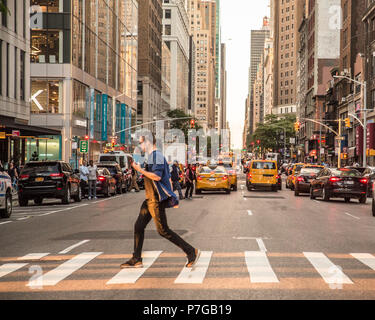 NEW YORK CITY - Giugno 16, 2018: Vista di midtown Manhattan a intersezione con auto, taxi e le persone in una tipica giornata di lavoro. Foto Stock