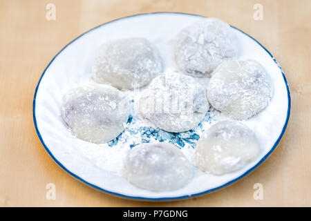 Molti round interi pezzi di mochi sticky riso glutinoso dessert torta wagashi daifuku riempito con rosso di adzuki fagiolo inceppamento piatto di riempimento vista dall'alto sulla piastra, ta Foto Stock