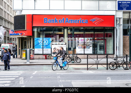 New York, Stati Uniti d'America - 7 Aprile 2018: Street view su Bank of America succursale in NYC con persone in attesa, pedoni che attraversano, crosswalk, bike, strada in Manhat Foto Stock