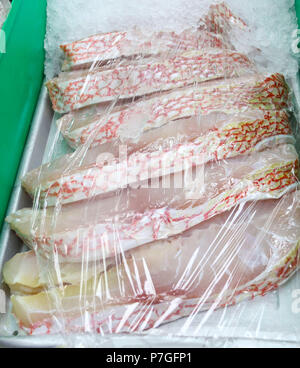 Red snapper bistecche avvolte nel cellophane su ghiaccio al mercato del pesce Foto Stock