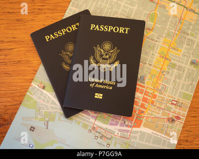 Noi due passaporti in cima a una mappa colorata. Fotografato dal di sopra su un tavolo di legno. Foto Stock