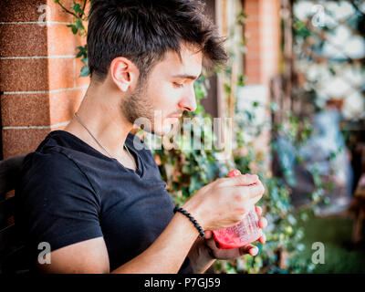 Giovane uomo a mangiare il gelato sulla terrazza Foto Stock