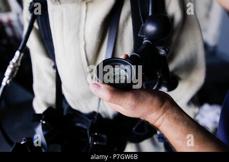 CONSTANTA, Romania - 20 giugno 2018: la mano di un rumeno marinaio militare è in possesso di un manometro collegato ad un vigile del fuoco di costume, il 20 giugno. Foto Stock