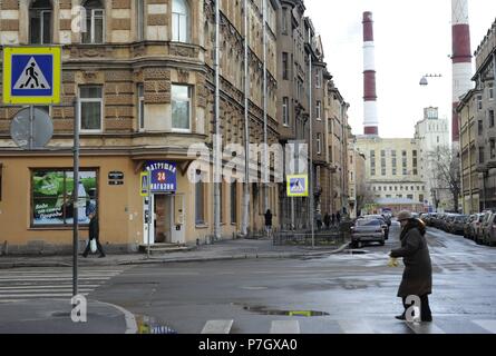 La Russia. San Pietroburgo. Sovetskaya. Donna che attraversa un crosswalk tenendo un sacchetto con tre mele sulle mani. Foto Stock