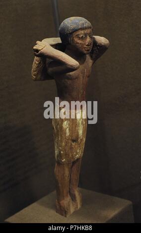 L'Egitto. Uomo che porta il grano. Statuette in legno si trova all'interno di tombe ricche.Lo Stato Museo Hermitage. San Pietroburgo. La Russia. Foto Stock